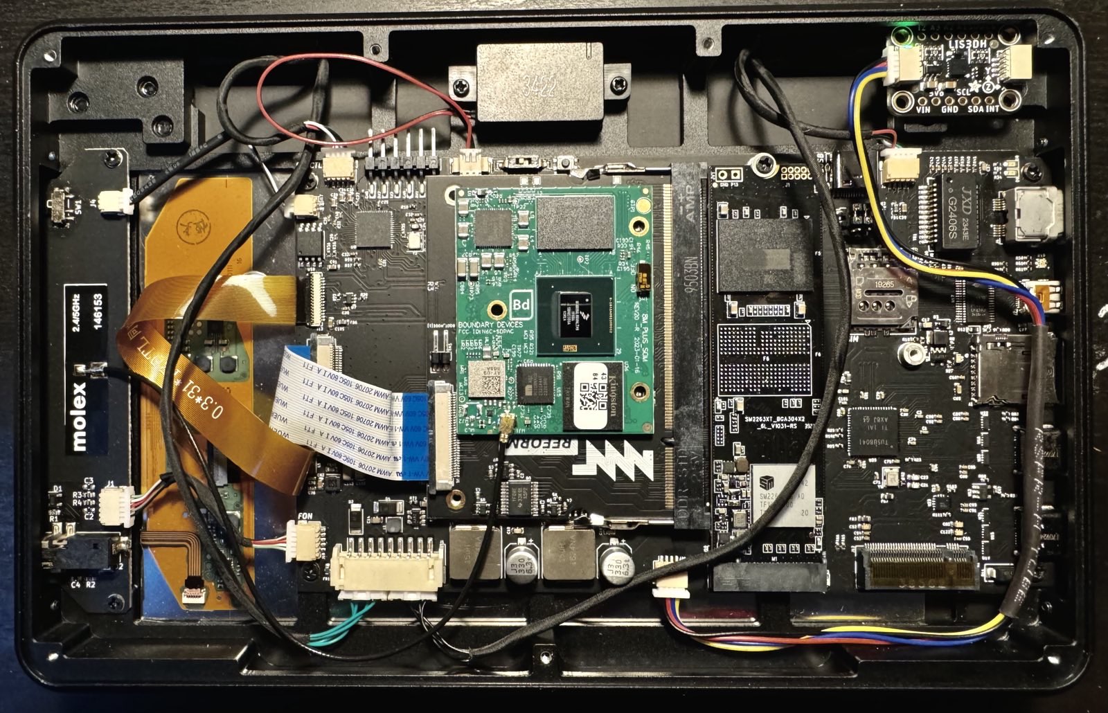 The inside of the MNT Pocket Reform top half with the accelerometer module
attached via a qwiic connector in the top right corner (the bottom left when
the lid is open with the screen facing you) with a green LED lit
up.